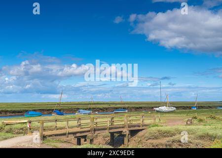 Farbenfrohe Boote auf dem Fluss Glaven in Blakeney, North Norfolk, Großbritannien Stockfoto