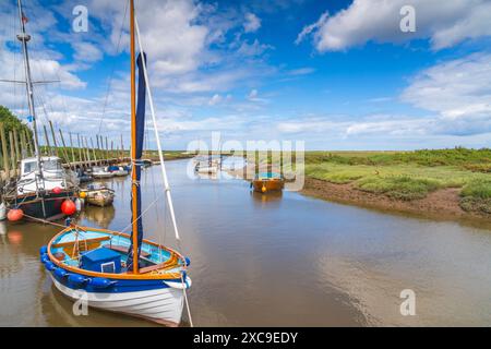 Farbenfrohe Boote auf dem Fluss Glaven in Blakeney, North Norfolk, Großbritannien Stockfoto