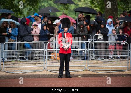 London, Großbritannien. Juni 2024. Schotten bewachen die Mall mit Mitgliedern der Öffentlichkeit hinter sich, die Regenschirme wegen der Wetterbedingungen halten. Die King's Birthday Parade, auch bekannt als Trooping the Colour, ist eine Militärprozession, die jedes Jahr zum offiziellen Geburtstag des britischen Monarchen stattfindet. (Foto: David Tramontan/SOPA Images/SIPA USA) Credit: SIPA USA/Alamy Live News Stockfoto
