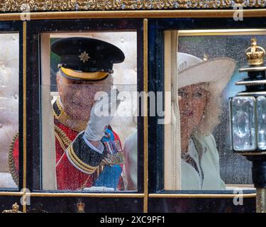 London, Großbritannien, 15. Juni 2024. König Charles und Königin Camilla kehren nach der Zeremonie „Trooping the Colour“ in einer Kutsche durch starken Regen zum Buckingham Palace zurück. Trooping the Colour findet jedes Jahr statt, um den offiziellen Geburtstag des Monarchen zu feiern. Dieses Jahr war es die Zeit der irischen Garde, ihre Farbe zu truppen. Die Prozession von und zu Horse Guards Parade verläuft entlang der Mall. Quelle: MartinJPalmer/Alamy Live News Stockfoto