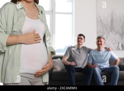 Schwangere Leihmutter und glückliches Schwulenpaar zu Hause, selektiver Fokus Stockfoto