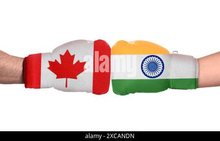 Politischer Konflikt. Männer in Boxhandschuhen mit Fahnen von Kanada und Indien kämpfen auf weißem Hintergrund, Nahaufnahme Stockfoto