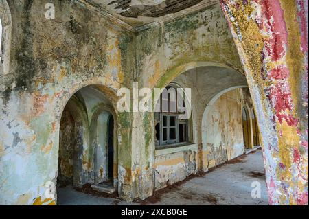 Verlassene Zimmer mit baufälligen Mauern und Bögen, bewachsen und in einem Zustand des Verfalls, italienischer Gouverneurspalast, Ruinen, italienische Kolonialsiedlung Stockfoto