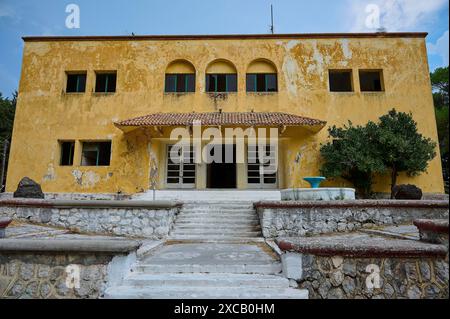 Ein altes gelbes, baufälliges Gebäude mit beschädigter Fassade und einer Treppe im Eingang, italienischer Gouverneurspalast, Ruinen, italienische Kolonialzeit Stockfoto