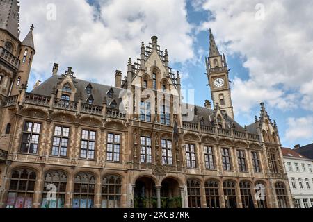 Gent, Belgien, 6. Juni 2024: Korenmarkt mit Altem Postamt mit Uhrenturm und Menschen, die die Altstadt von Gent hinunterlaufen Stockfoto