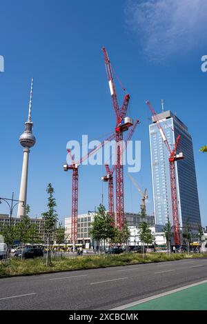 Der berühmte Alexanderplatz in Berlin mit dem Fernsehturm und vier roten Baukränen Stockfoto