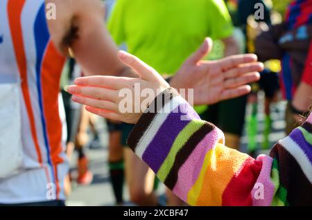 Marathon-Laufrennen, Unterstützung von Läufern auf der Straße, Kinderhände, die highfive schenken, Sportkonzept Stockfoto