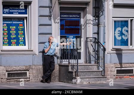 Ein Mann, der an einer Wechselstube steht, raucht eine Zigarette. Am 12. Juni verhängten die Vereinigten Staaten im Namen des Finanzministeriums Sperrsanktionen gegen Russland, insbesondere gegen die Moskauer Börse und ihre Mitgliedsgruppe, das nationale Clearing Center (NCC). Die Aufnahme von Unternehmen in die SDN-Liste bedeutet tatsächlich Isolation vom Dollarsystem, so dass der Börsenhandel in Dollar und Euro in Russland eingestellt wurde. Sekundärsanktionen waren natürliche und juristische Personen aus China, Belarus und anderen Ländern. Die Politik des Sanktionsdrucks auf die Russische Föderation Stockfoto