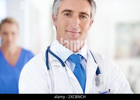 Krankenhaus, Medizin und Porträt des Mannes Doktor mit positivem, selbstbewusstem und Stolz auf Karriere. Lächeln, Gesundheit und professionelle reife männliche Kardiologie Stockfoto