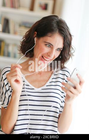 Frau Musik hören mit Smartphone Stockfoto