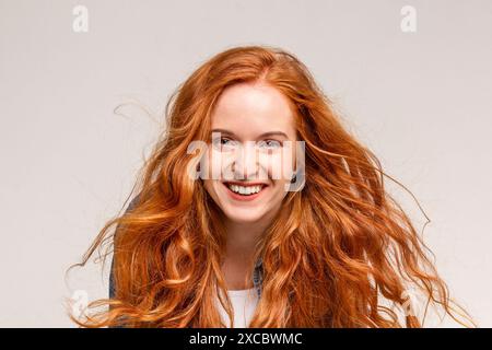 Eine junge Frau mit langen roten Haaren lächelt in die Kamera Stockfoto