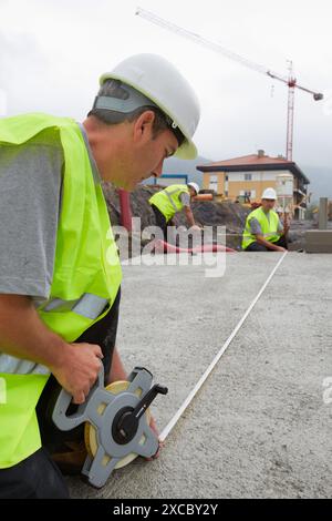 Arbeiter mit Schutzausrüstung, PSA, Maßnahmen in der Urbanisierung, draußen, Wohnbau, Maßband, Baskenland, Spanien Stockfoto