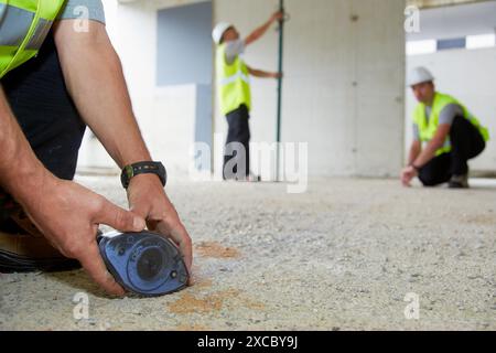 Arbeiter mit persönlicher Schutzausrüstung, PSA, Kennzeichnungslinien für den Bau von Innenwänden, Line Tracer, Gehäusebau, Concre Stockfoto