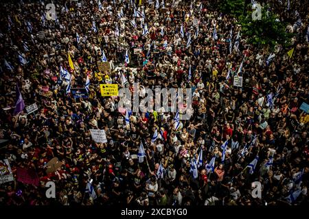 Tel Aviv, Israel. Juni 2024. Während einer Demonstration in Tel Aviv am Samstag, den 15. Juni 2024, halten Demonstranten Schilder hoch und schwenken die israelische Flagge. Zehntausende Demonstranten versammelten sich am Samstagabend an Dutzenden von Orten in ganz Israel und riefen, den Krieg in Gaza zu beenden, um eine Geiselnahme und neue Wahlen zu vereinbaren, nur wenige Stunden nach der Nachricht von acht israelischen Soldaten, die am Samstagmorgen in Rafah bei einer Explosion getötet wurden. Foto von Eyal Warshavsky. Quelle: Eyal Warshavsky/Alamy Live News Stockfoto