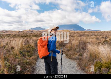 Schöne asiatische Reisende Frau Wandern und genießen mit vulkanischen Bergen und goldenen Wiesen in Tongariro Alpin Crossing Track am sonnigen Tag in Nord I Stockfoto