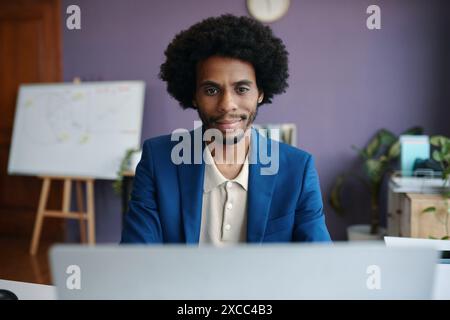 Porträt eines lächelnden Geschäftsmannes, der Videoanrufe mit Kollegen führt Stockfoto