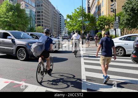 Washington DC, USA - 30. Mai 2024: Radfahrer und Fußgänger zwischen Autos auf dem Weg zur Arbeit im Zentrum von Washington DC Stockfoto