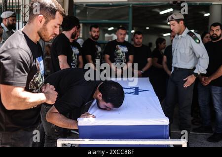 Beit Jann, Israel. Juni 2024. Ein Mann weint auf den mit Fahnen überzogenen Sarg des israelischen Soldaten Wassem Mahmoud, der bei seiner Beerdigung in Beit Jann bei der Explosion eines Panzerpersonals in der Nähe der Stadt Rafah im Süden des Gazastreifens getötet wurde. Acht israelische Soldaten seien bei Kämpfen in Rafah im südlichen Gazastreifen getötet worden, sagten die Streitkräfte am Samstag. Quelle: Ilia Yefimovich/dpa/Alamy Live News Stockfoto