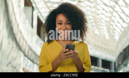 Glückliche afroamerikanische Frau freut sich Freude Handy Smartphone Handy Handy Handy ja aufgeregt emotionale Käufer Shopping Mall Verkäufe Rabatte schwarz Stockfoto