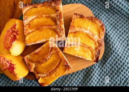 Ein Dessert aus geschnittenen Pfirsichen ist auf einem hölzernen Schneidebrett. Das Dessert ist mit Zucker bedeckt und sieht köstlich aus Stockfoto
