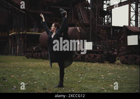 Ballerina vor dem Hintergrund einer riesigen verlassenen Fabrik Stockfoto