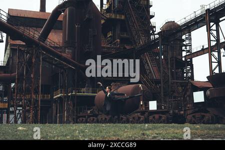 Ballerina vor dem Hintergrund einer riesigen verlassenen Fabrik Stockfoto