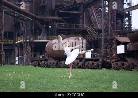 Ballerina vor dem Hintergrund einer riesigen verlassenen Fabrik Stockfoto