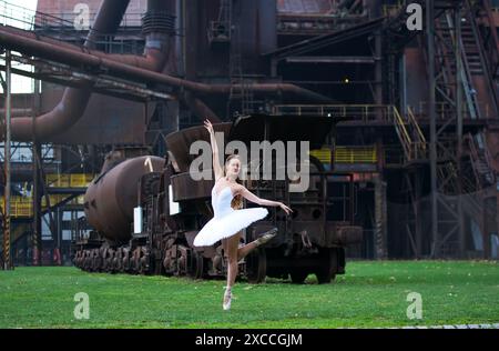 Ballerina vor dem Hintergrund einer riesigen verlassenen Fabrik Stockfoto