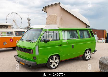 Strand Scheveningen, Niederlande - 26. Mai 2024: Grüner VW Kombi-wagen parkt in der Nähe des Piers scheveningen Stockfoto