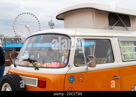 Strand Scheveningen, Niederlande - 26. Mai 2024: Oranger VW Kombi-wagen parkt in der Nähe des Piers scheveningen Stockfoto