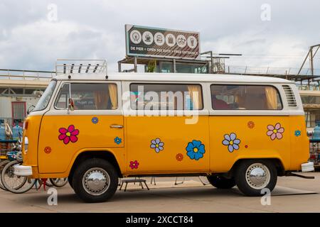 Strand Scheveningen, Niederlande - 26. Mai 2024: Hellgelber VW Kombi-wagen mit Blumenmuster auf der Aircooler Oldtimer-Show Stockfoto