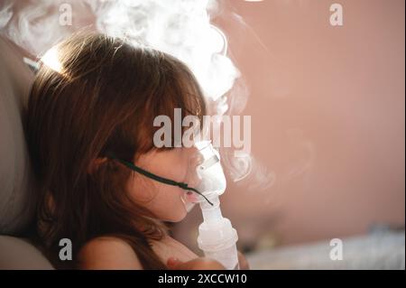 Kind mit Hustenproblem, das eine Vernebler-Maske benutzt, um zu heilen Stockfoto