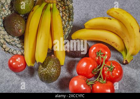 Bio-kaliumreiche Lebensmittel, Avocados, Bananen und Tomaten. Gesunde Sommerkost in einem Leinenkorb!!! Stockfoto