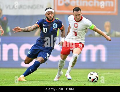 Hamburg. Juni 2024. Der polnische Piotr Zielinski (R) streitet mit dem niederländischen Memphis Depay während des Gruppenspiels der UEFA Euro 2024 zwischen Polen und den Niederlanden am 16. Juni 2024 in Hamburg. Quelle: Ren Pengfei/Xinhua/Alamy Live News Stockfoto