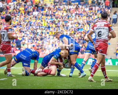 Das Finale Des Betfred Challenge Cups 2024. Joe Bullock und Josh Drinkwater machen einen Tackle auf Liam Farrell Stockfoto
