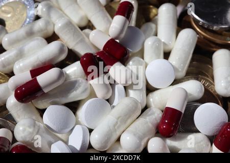 Weiße und rote Kapselpillen wurden über mehrere Münzen verteilt. Stockfoto