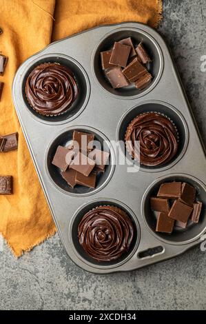 Schokoladen-Cupcakes und Milchschokolade-Quadrate Stockfoto