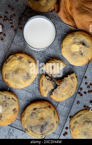 Sechs Schokoladenkekse auf einem Backblech mit einem Glas Milch Stockfoto