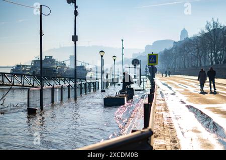 Menschen beobachten die überquerende Donau auf dem geschlossenen Buda-Werft in der Wintersonne in Budapest am 29. Dezember. 2023 Stockfoto