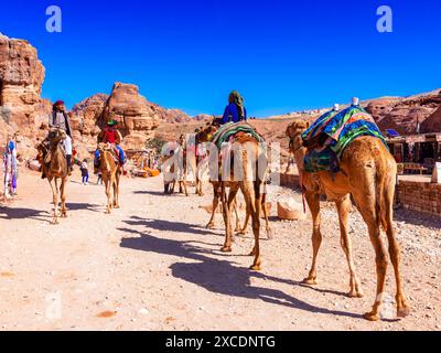 Wadi Musa, Jordanien 4. März: Beduinenmänner reiten auf Kamelen mit bunten Decken an der antiken Stätte Petra in Jordanien. Naher Osten Stockfoto