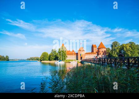 Vilnius, Litauen, 29. September 2023, hölzerne Brücke zu den Ruinen des trakai-Palastes in der Nähe von vilnius in einer Naturlandschaft mit Seewasser und blauem Himmel im Sommer Stockfoto