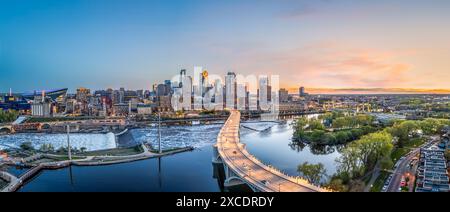 Die Skyline der Innenstadt von Minneapolis, Minnesota, USA über dem Fluss in der Abenddämmerung. Stockfoto