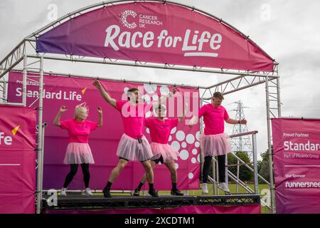 Warrington, Cheshire, Großbritannien. Juni 2024. Das jährlich stattfindende 10K-Rennen um das Leben zur Unterstützung von Cancer Research UK fand im Victoria Park, Warrington, statt. Die lokalen Fitnesslehrer wiesen die Läufer an, sich vor dem Rennen aufzuwärmen. Credit: John Hopkins/Alamy Live News Stockfoto