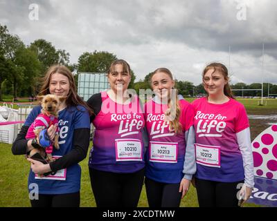 Warrington, Cheshire, Großbritannien. Juni 2024. Das jährlich stattfindende 10K-Rennen um das Leben zur Unterstützung von Cancer Research UK fand im Victoria Park, Warrington, statt. Gekleidet in Race for Life Shirts – sogar der Hund trug einen besonderen Top-Credit: John Hopkins/Alamy Live News Stockfoto