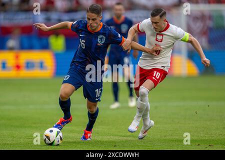 Joey Veerman (Niederlande) und Piotr Zielinski (Polen) beim Spiel der UEFA EURO Gruppe D 2024 zwischen Polen und den Niederlanden im Volksparkstadion in Hamburg am 16. Juni 2024 (Foto: Andrew SURMA/SIPA USA). Stockfoto