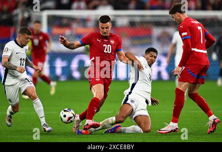 Gelsenkirchen, Deutschland. Juni 2024. Fußball, UEFA Euro 2024, Europameisterschaft, Serbien - England, Vorrunde, Gruppe C, Spieltag 1, Arena auf Schalke, Englands Spieler Kieran Trippier (l) und Jude Bellingham (2. von rechts) im Kampf gegen die serbischen Spieler Sergej Milinkovic-Savic (2. von links) und Dusan Vlahovic. Quelle: Bernd Thissen/dpa/Alamy Live News Stockfoto