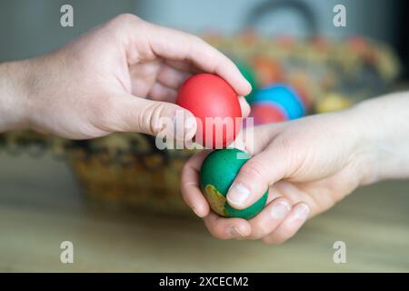 ostereierklopfen, Mutter und Sohn Eierklopfen neben Korb mit ostereiern, selektiver Fokus, Nahaufnahme der Hände Eierklopfen Stockfoto