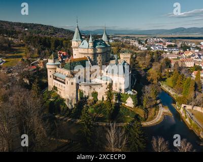 Panoramablick auf das Schloss Bojnice in der Slowakei. Vogelperspektive: Altes Wahrzeichen und historisches Denkmal, alter Palast der Könige und Festung auf einem Hügel zwischen Waldbäumen und Gebäuden der Stadt Stockfoto