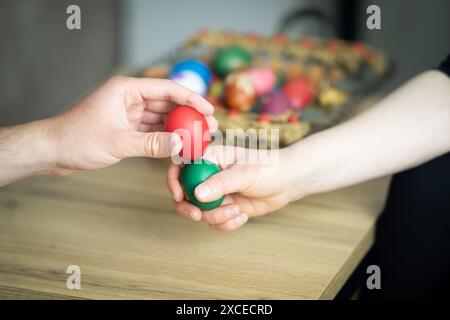 ostereierklopfen, Mutter und Sohn Eierklopfen neben Korb mit ostereiern, selektiver Fokus, Nahaufnahme der Hände Eierklopfen Stockfoto