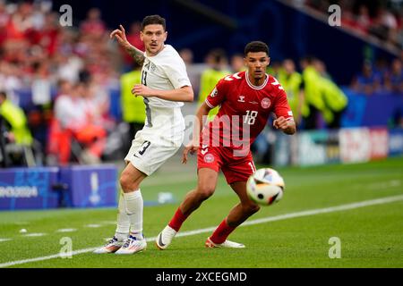 Der slowenische Erik Janza (links) und der dänische Alexander Bah kämpfen während des Gruppenspiels der UEFA Euro 2024 in der Stuttgart Arena um den Ball. Bilddatum: Sonntag, 16. Juni 2024. Stockfoto